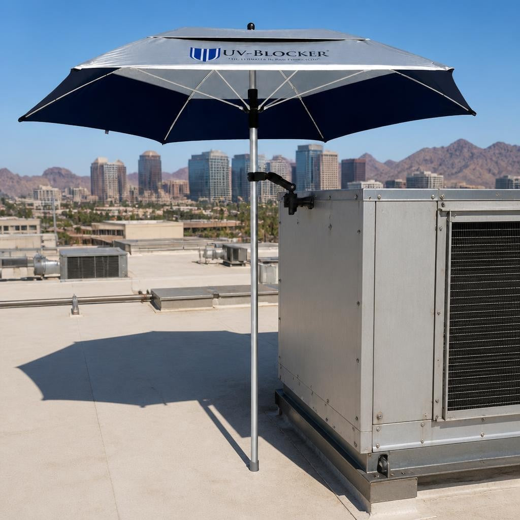 UV-Blocker ServiceShield umbrella clamp-mounted on a rooftop HVAC unit, providing shade for technicians with a city skyline and mountains in the background — occupational sun protection for HVAC and roofing work