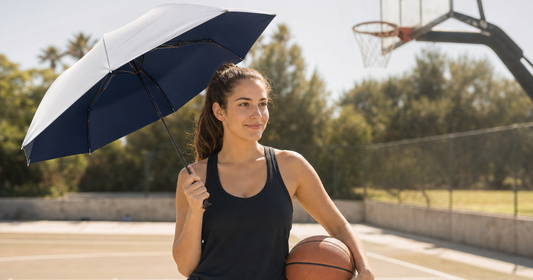 Sun protection for basketball — player resting courtside with UV umbrella shade on outdoor basketball court