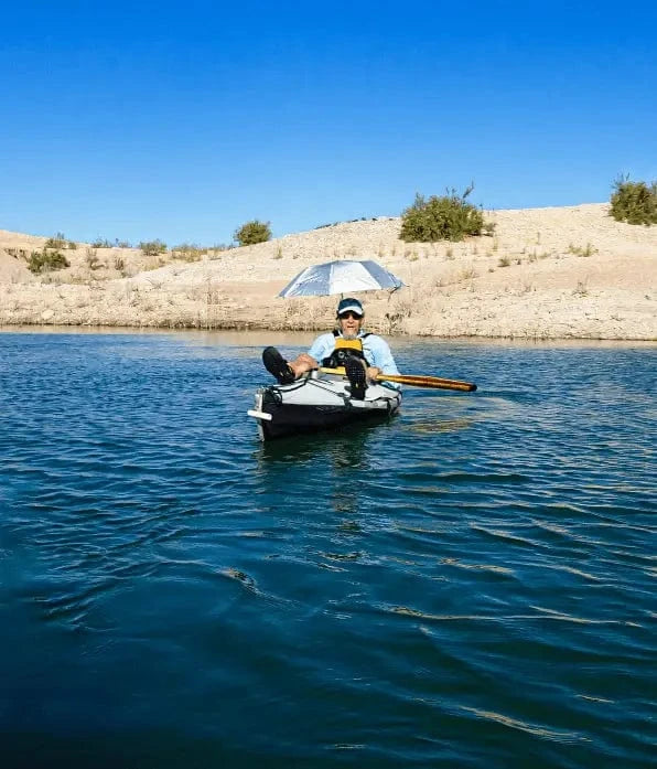 Hero Kayaker on calm water under umbrella